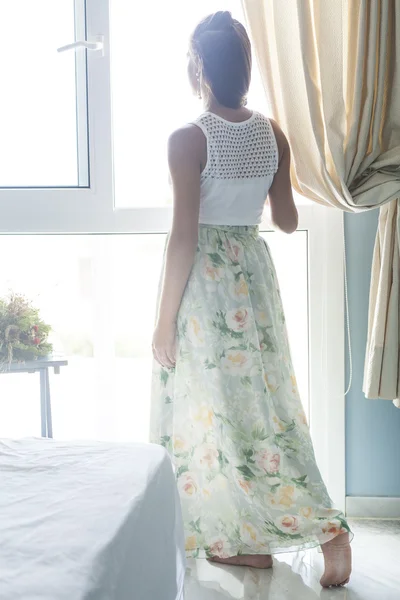 Young woman is near the window — Stock Photo, Image