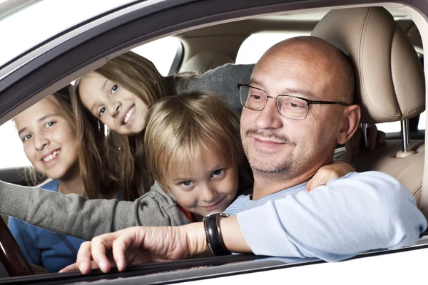 Huppy padre con niños en un coche Fotos de stock libres de derechos