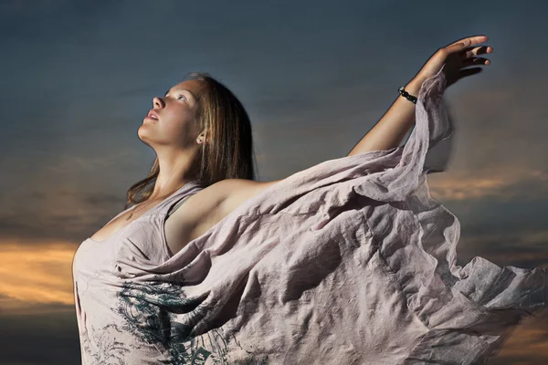 Молодая женщина на фоне закатного неба — стоковое фото