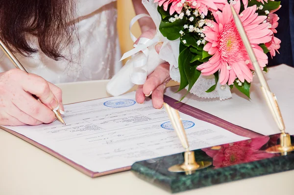 Un couple nouvellement marié signe des documents — Photo