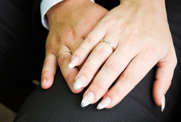 Жених надевает обручальное кольцо на невесту
