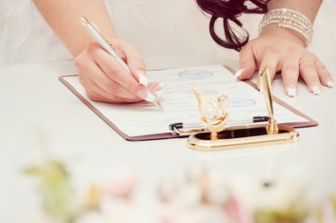 Yeni evli çift belgeleri imzalar