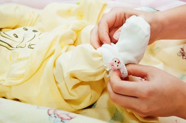 Mãe veste seu bebê — Fotografia de Stock