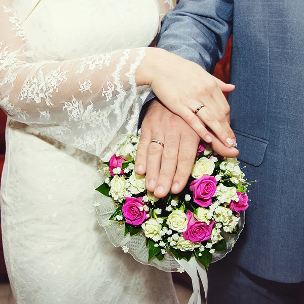 Mani della sposa e dello sposo sdraiato sul bouquet da sposa — Foto Stock