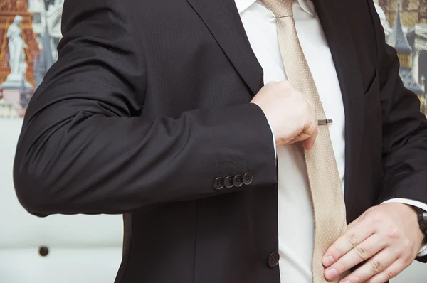 Gut gekleideter Mann beim Anpassen seiner Krawatte — Stockfoto