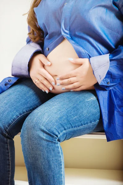 Mujer embarazada y sus manos — Foto de Stock