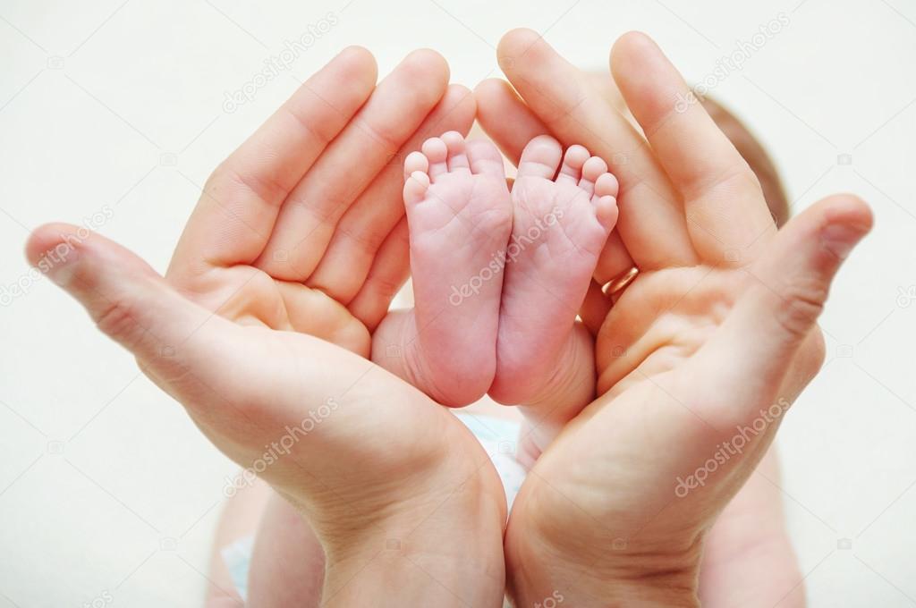 Feet of newborn baby in mothers hands