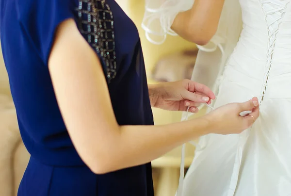 Helping the bride to put her wedding dress on — Stock Photo, Image