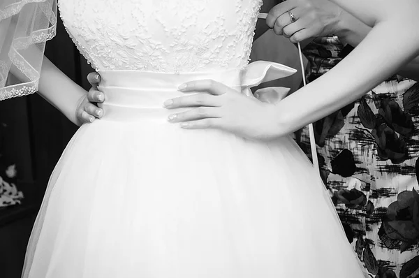 Помогаю невесте надеть свадебное платье — стоковое фото