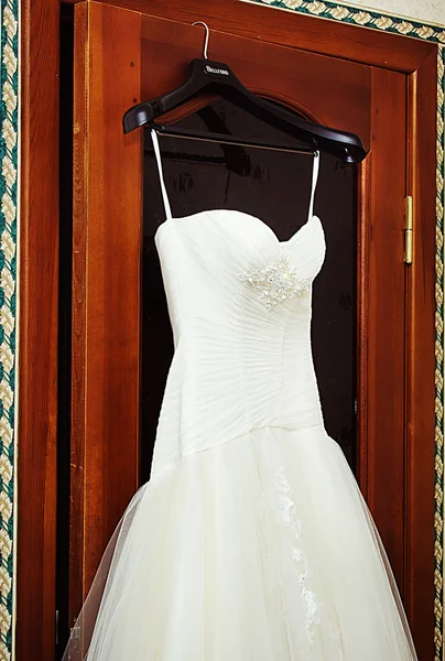 Witte bruiloft jurk opknoping op een schouders — Stockfoto