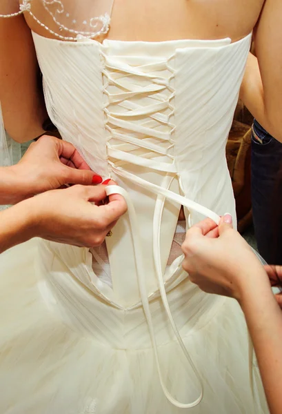 Ajudar a noiva a vestir um vestido de noiva — Fotografia de Stock