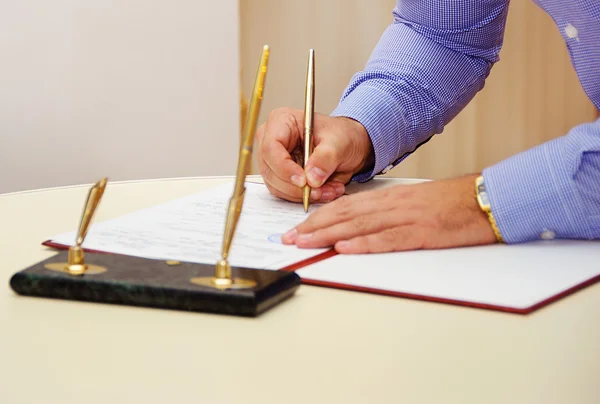 Бизнесмен подписывает документ. — стоковое фото