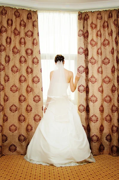 Image of beautiful bride standing at window — Stock Photo, Image