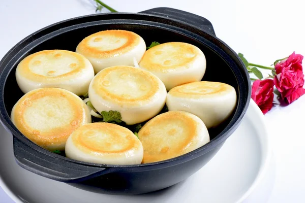 Comida chinesa: Dumplings torrados em um pote preto — Fotografia de Stock