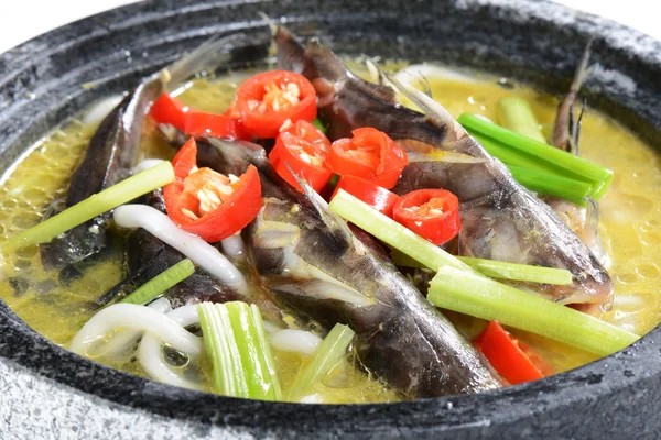 Kinesisk mat: kokt fisk i en sten kruka Stockbild