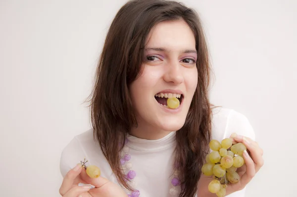 Jeune femme mangeant des raisins — Photo