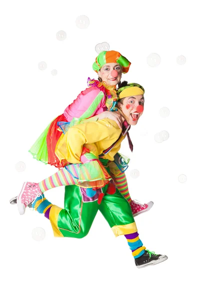 Дві веселі клоуни в мильних бульбашках — стокове фото