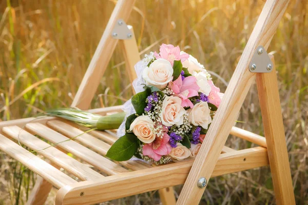 Букет невесты на стуле — стоковое фото