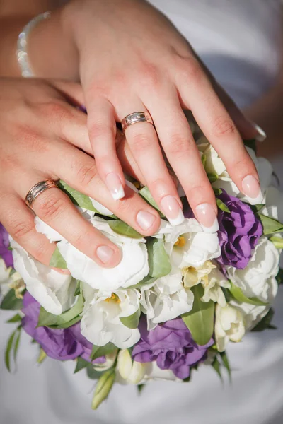 Mani e anelli su bouquet da sposa — Foto Stock