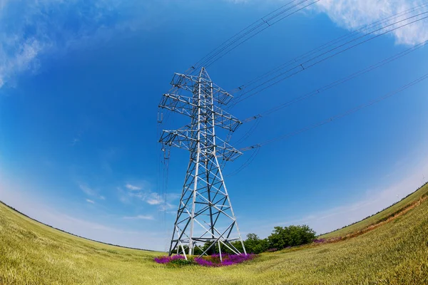 Hoog-voltage elektriciteitsmasten tegen blauwe hemel — Stockfoto