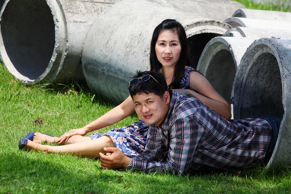 Casal romântico relaxante em tubo de cimento no parque — Fotografia de Stock