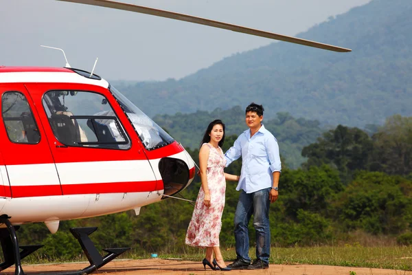 Glückliches Liebespaar, das mit dem Hubschrauber anreist und lächelt — Stockfoto