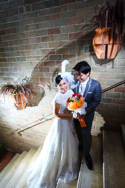 Schönes Hochzeitspaar mit Blumenstrauß in einem Schloss — Stockfoto