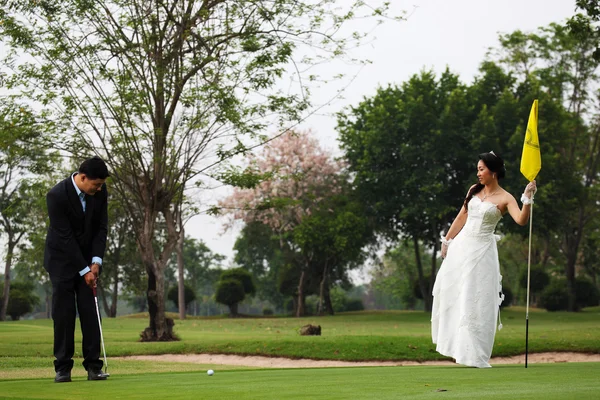 Novia y novio jugando golf Imágenes de stock libres de derechos