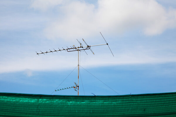 old television antenna against blue sky