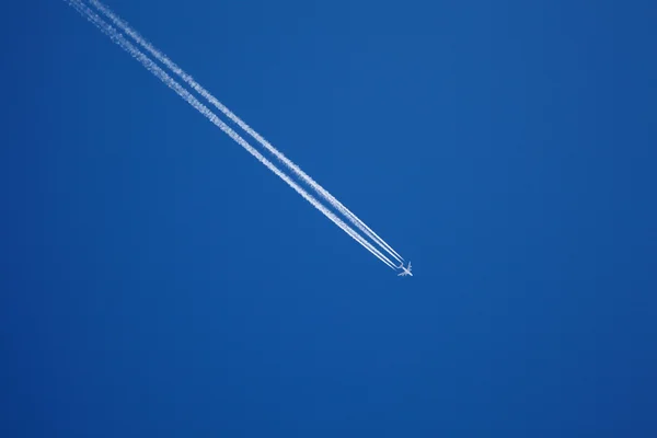 Mavi gökyüzünde uzun bir jet uçağı yolu Stok Fotoğraf