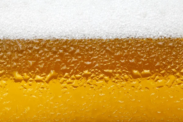 Bir bira köpük ve kabarcıklar ile yakın çekim resim — Stok fotoğraf