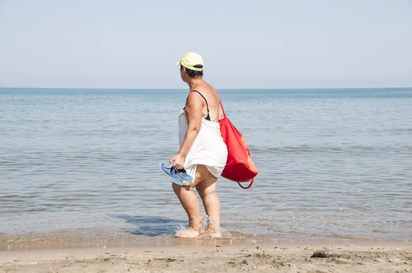 Elderly and fat old ladie walk on the beach — Stock Photo, Image