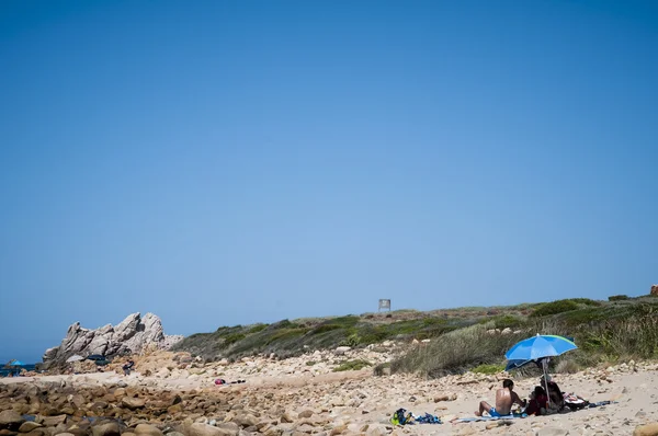 Beach umbrella and towel on the sand — Stock Photo, Image