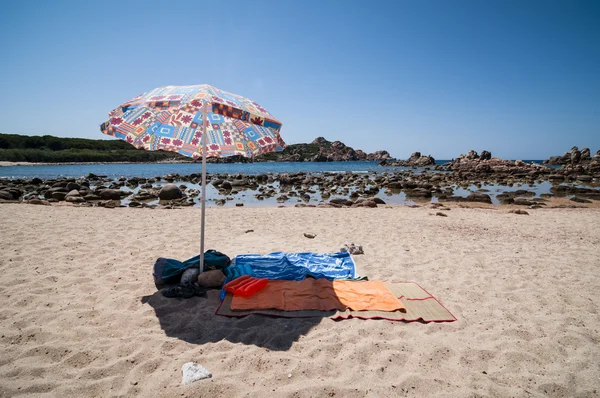 Beach umbrella and towel on the sand — Stock Photo, Image