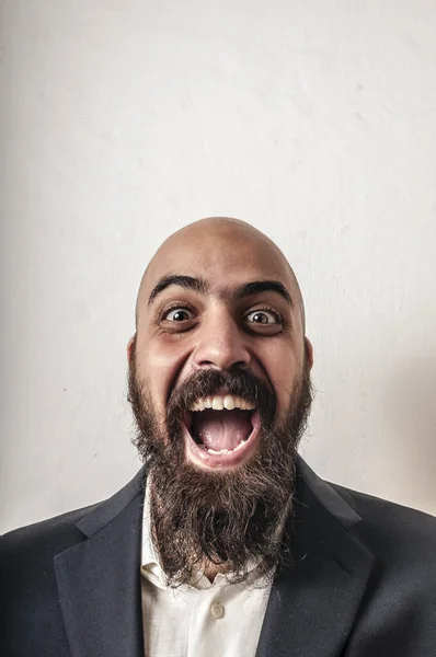 Элегантный бородатый мужчина с курткой и смешными выражениями лица — стоковое фото