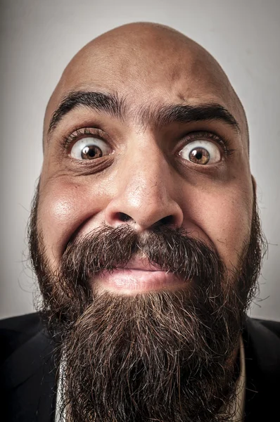 Элегантный бородатый мужчина с курткой и смешными выражениями лица — стоковое фото