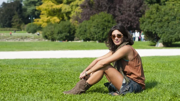 Beautiful girl with scarf and sunglasses on the lawn — Stock Photo, Image