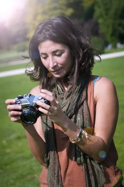 Beautiful girl with scarf and camera on the lawn — Stock Photo, Image