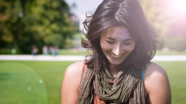 Hermosa chica sonriendo con bufanda en el césped —  Fotos de Stock