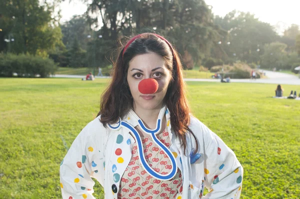 Clown girl with red nose at the park — Stock Photo, Image