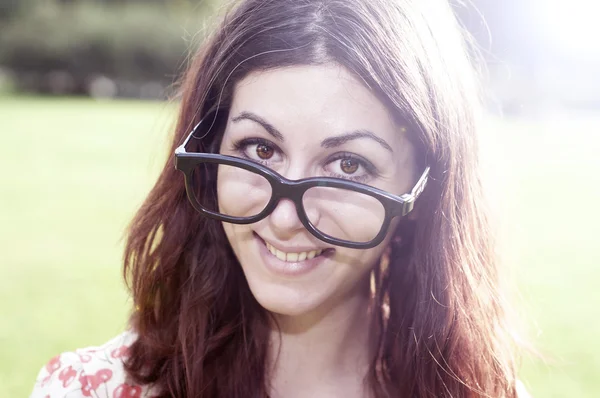 公園での大きなガラスを持つ少女の笑顔 — ストック写真