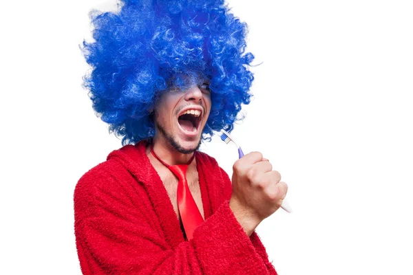 Crazy guy with a toothbrush, wig and bathrobe singing — Stock Photo, Image