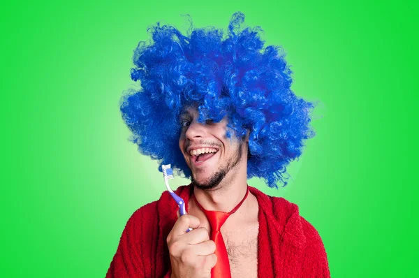 Homem louco com uma escova de dentes, peruca e roupão de banho cantando — Fotografia de Stock