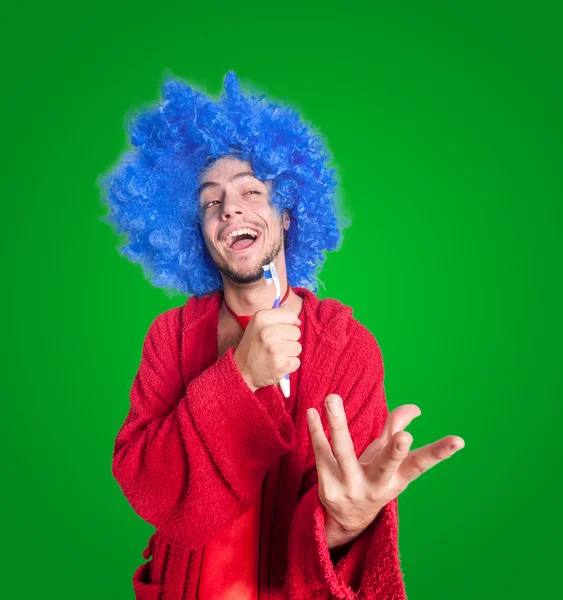 Homem louco com uma escova de dentes, peruca e roupão de banho cantando — Fotografia de Stock