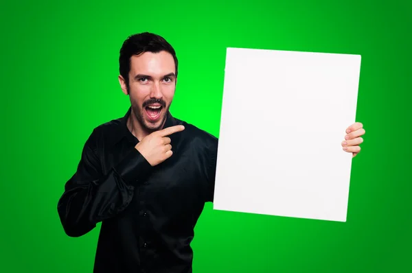 Uomo in possesso di bordo bianco vuoto sul backgroud verde — Foto Stock