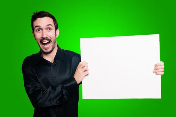 Homem feliz segurando placa branca em branco no backgroud verde — Fotografia de Stock