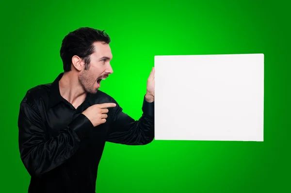 Homem segurando placa branca em branco no backgroud verde — Fotografia de Stock