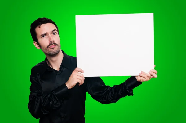 Homem segurando placa branca em branco no backgroud verde — Fotografia de Stock