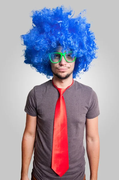 Drôle gars avec perruque bleue lunettes vertes et cravate rouge — Photo
