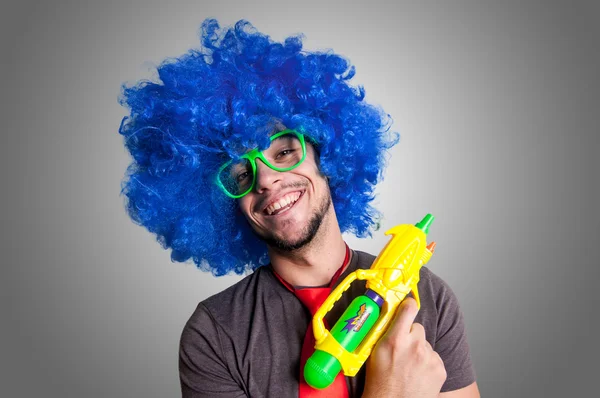 Grappige kerel met blauwe pruik en water gun automatische waterpistool — Stockfoto